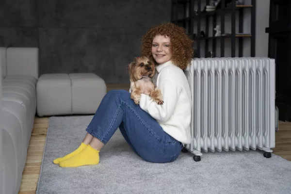 full shot woman sitting near heater with dog (1) (1)
